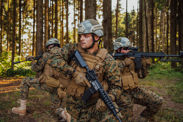 Fototapeta premium Soldier fighters standing together with guns. Group portrait of US army elite members, private military company servicemen, anti terrorist squad