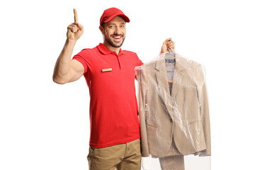 Worker holding a suit on a hanger with a plastic cover and pointing up