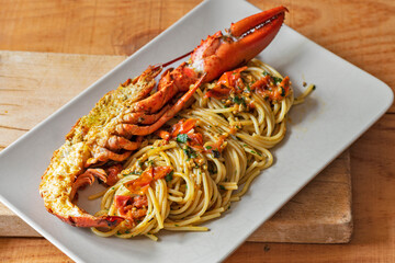Rectangular plate with plenty of spaghetti and half a lobster.