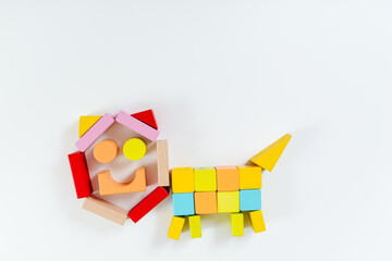 Colorful children's wooden construction set. Cat or dog figure. White background. Top view,copy space. Natural materials. Learning and education concept.