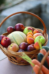 Two wicker baskets with healthy seasonal food in a garden. Selective focus.