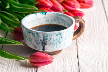 Spring composition with a cup of coffee and tulips.