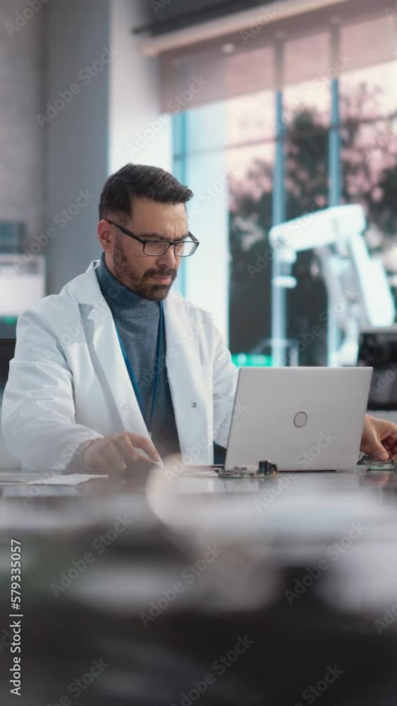 Aufkleber vertical screen: portrait of professional male scientist working in an industrial lab using laptop c