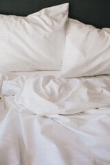 Bed and white linens in a hotel room.