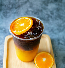 iced coffee drink menu Orange Americano fusion with fresh orange fruit mixed in a plastic cup, drink menu product.
