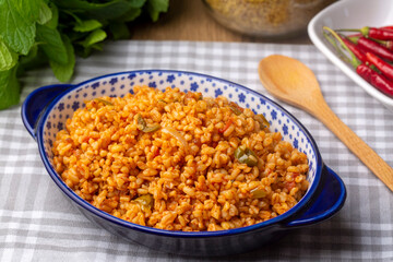 Traditional turkish bulgur pilaf with tomato sause in plate (Turkish name; meyhane pilavi)