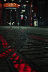 Red luminous rails on the forecourt in front of a headquarter in Bochum, Germany. - obrazy, fototapety, plakaty