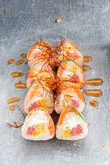 Set of sushi rolls with salmon, tuna, cream cheese, sweet pepper, rice paper and sauce.