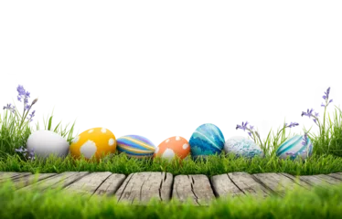 Fotobehang A collection of painted easter eggs celebrating a Happy Easter template with a wooden bench to place products with green grass and transparent background © Duncan Andison