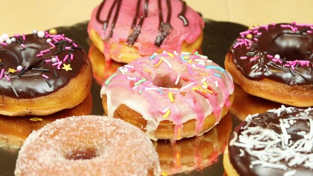 variety of glazed donuts spinning on a turntable