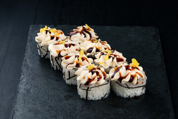 Set of sushi rolls with tuna, cream cheese, avocado, mango and sauce.