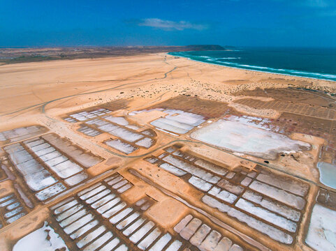 Aerial photos of Salines in Santa Maria, Sal Island in Cabo Verde showcase stunning salt flats, colorful patterns created by salt ponds, machinery used for salt harvesting