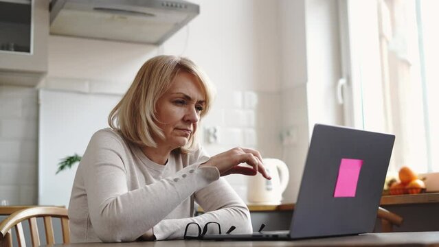 Mature woman sad with laptop at home. Finance problems 