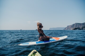 Woman sea sup. Close up portrait of happy young caucasian woman with long hair looking at camera...