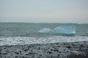 Crystal clear ice chunks near the black sand of Diamond beach in Fellsfjara, Jokulsarlon on Iceland