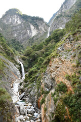 Fototapeta na wymiar Vertical shot of a river flowing through rocks in Xiulin, Hualien, Taiwan