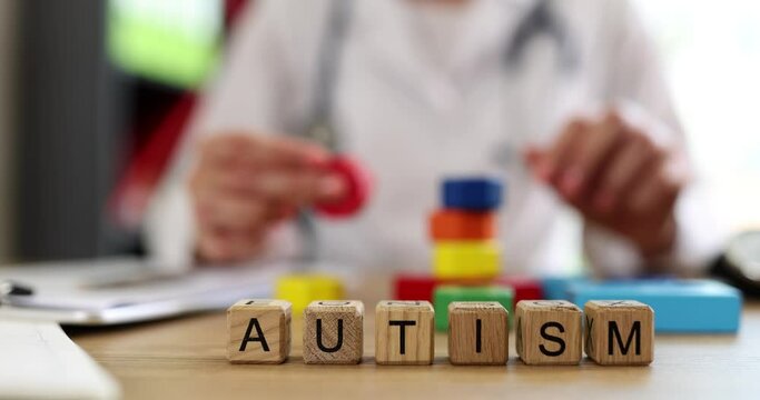 Word autism psychiatrist with colored blocks at hospital table