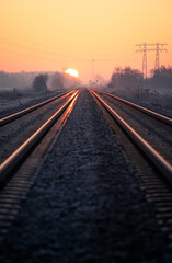 Naklejka na ściany i meble Empty railway track during a colourful, winters dawn.