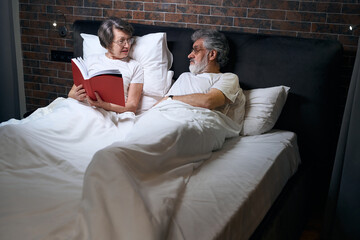 Obraz premium Male and lady resting in bed, reading