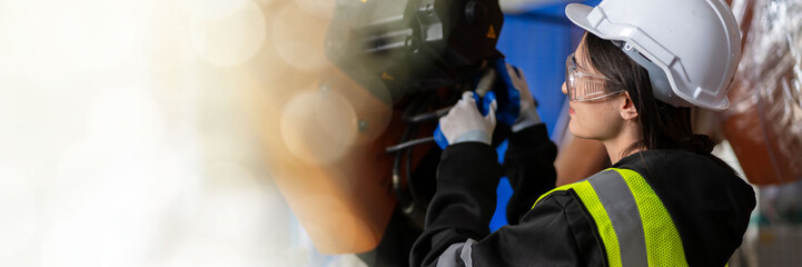 web banner A team of female engineers meeting to inspect computer-controlled steel welding robots. Plan for rehearsals and installation for use.