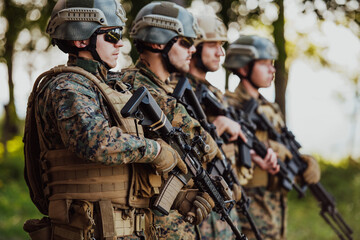 Fototapeta premium Soldier fighters standing together with guns. Group portrait of US army elite members, private military company servicemen, anti terrorist squad
