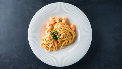 Spaghetti pasta with shrimps, cream sauce and greens.