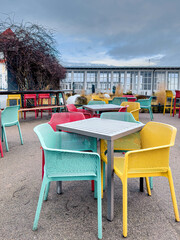 Fototapeta na wymiar Multi-colored chairs on the terrace of a cafe by the sea.