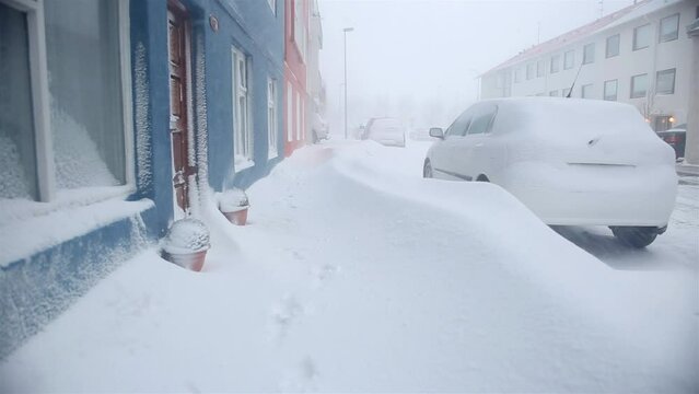 Deep snowdrifts blocking sidewalk and cars Reykjavik Iceand winter