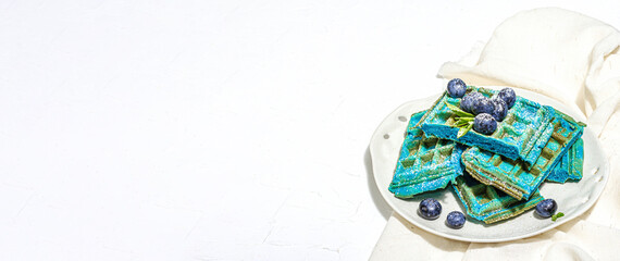 Homemade Belgium Waffles with blueberries. Gluten-free blue dessert, fresh fruits and mint