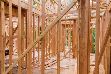 Construction of stick house involves assembling timber beams into truss frames.