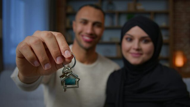 Happy owners property multiracial family ethnic couple showing bunch of keys new home relocation homeowners african american man muslim woman in hijab rent flat buy dream house apartment loan mortgage