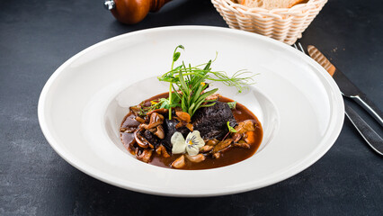 Fried beef fillet steak with mushrooms, sauce and greens.
