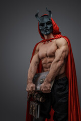 Shot of muscular sorcerer man of dark brotherhood dressed in red mantle and evil mask.