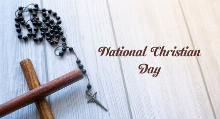 A brown wooden cross and Christian prayer beads in white background, National Christian Day concept Selective focus