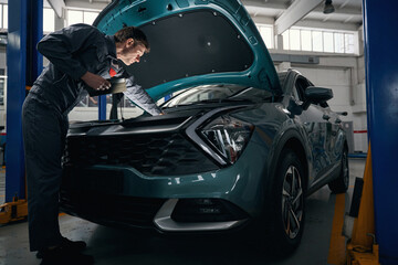 Mechanic inspecting technical condition of car engine