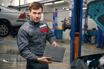 Portrait of man changing spare parts in the car