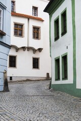 Narrow street with facades of historic houses and paved sidewalk in the center of Ceský Krumlov, Czech Republic