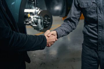 Mechanic talking with client and shaking hands - obrazy, fototapety, plakaty