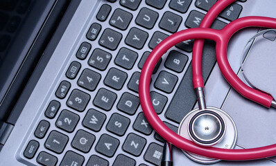 Zbliżenie na klawiaturę laptopa i stetoskop u lekarza - obrazy, fototapety, plakaty