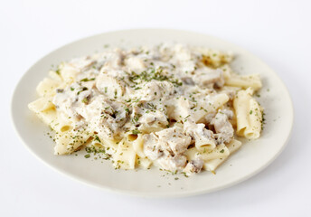 Pasta with chicken and mushrooms in creamy cheese sauce on a white background