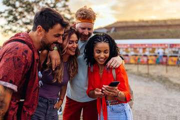 Fototapeta premium Friends texting with absent friend at festival.