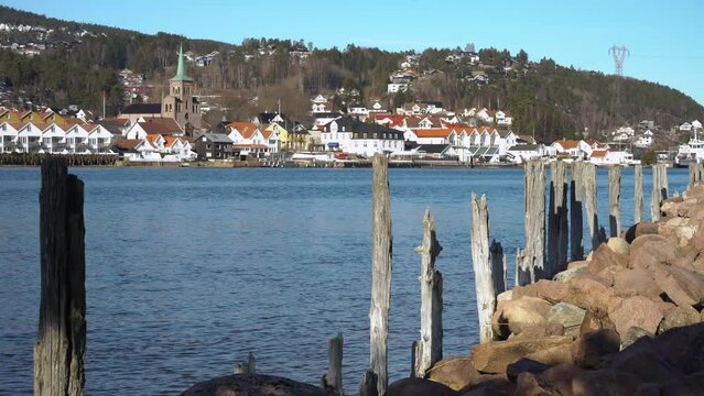 Old wooden breakwaters along the shore of Drammen Fjord. On the opposite shore is the town of Svelvik
