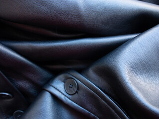 Detail of a black pleated leather garment