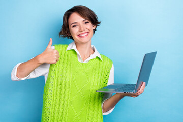 Photo of cheerful business manager programmer it specialist thumb up like her high performance lenovo laptop isolated on blue color background