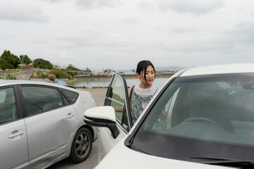 沖縄でレンタカーに乗る女性