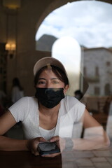 Dark-skinned woman wearing a black mask to prevent COVID-19