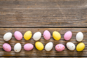 Multicolored Easter eggs on a wooden background, flat lay.