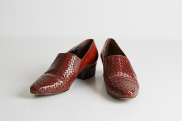 Pair of retro red slip-on shoes. Stylish woven-leather material. 