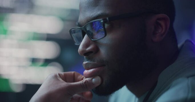 Zoom In, Close Up Portrait of Male Programmer Developing New Software, Coding, Managing Cybersecurity Project. Black Man Working on Computer, Lines of Code Language Reflecting on his Glasses