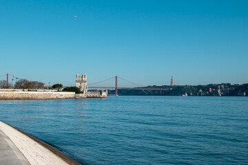 Obraz premium View of Tower of Belem and Ponte 25 de Abril Bridge at sunset, Lisbon, Portugal on the Tagus River